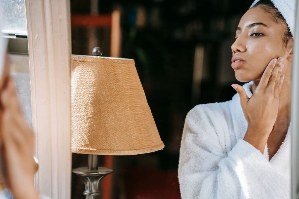 Woman applying moisturizer as part of a simple skincare routine